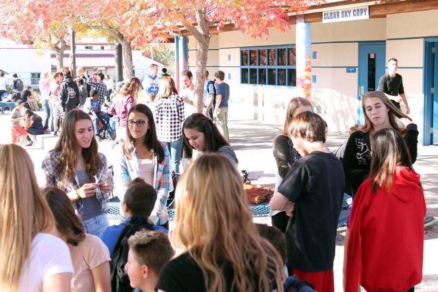 Students enjoy their lunch under the color-changing leaves of Fall