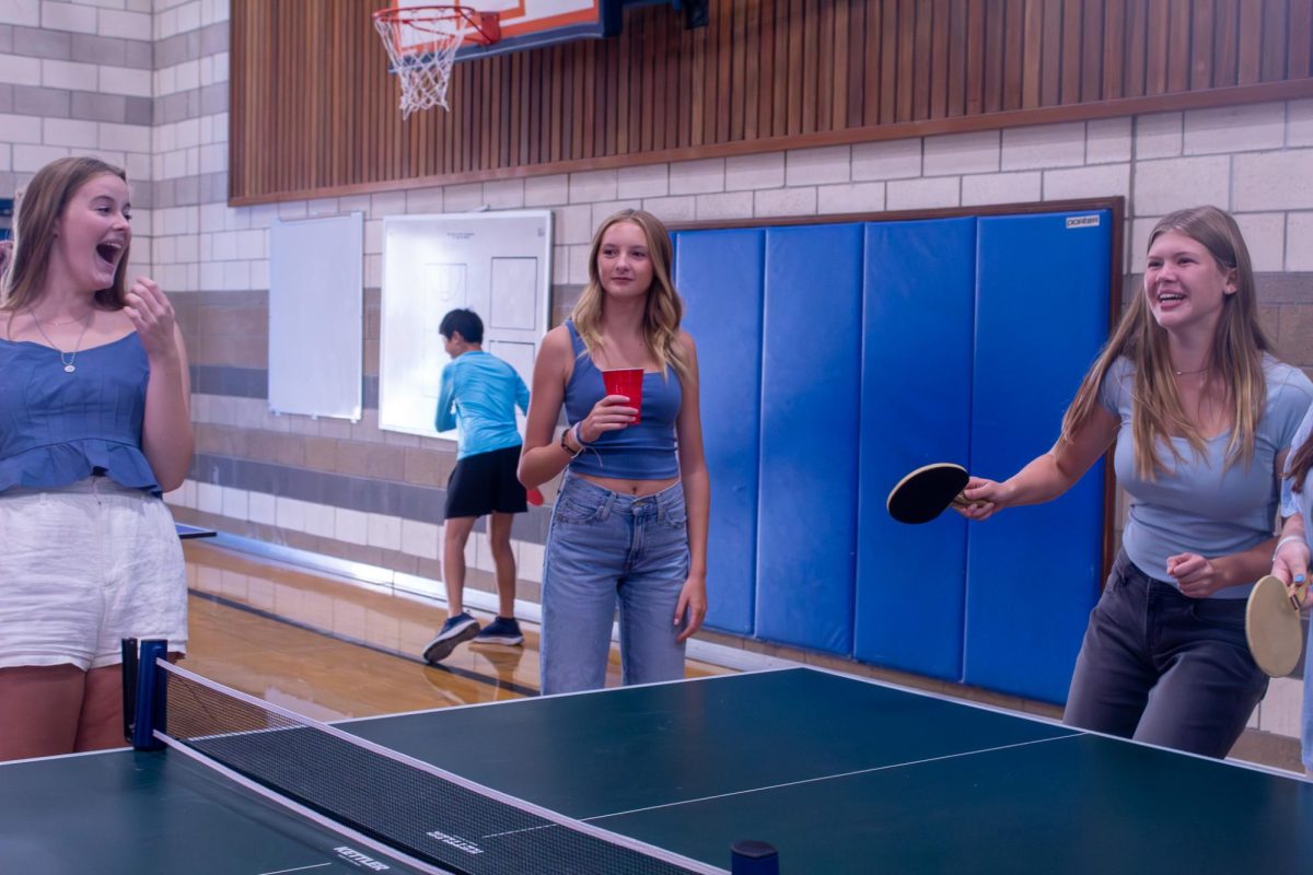 Students playing pingpong in large gym during Carnival.